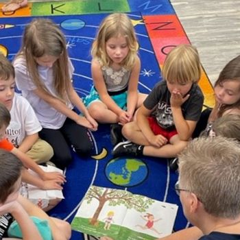 Kids sitting in a circle on a colorful patterned carpet