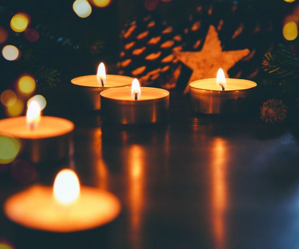 Closeup of lit candles in a dark setting