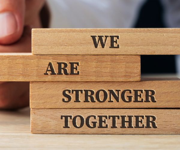 Stacked wooden blocks that say "We are stronger together"