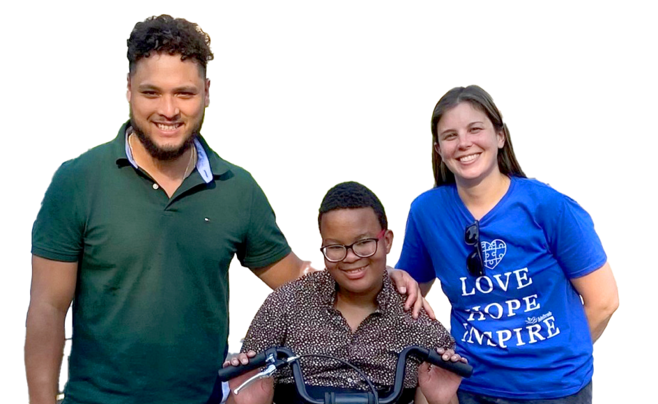 Two adults gathered around a student, all three smiling for a photograph